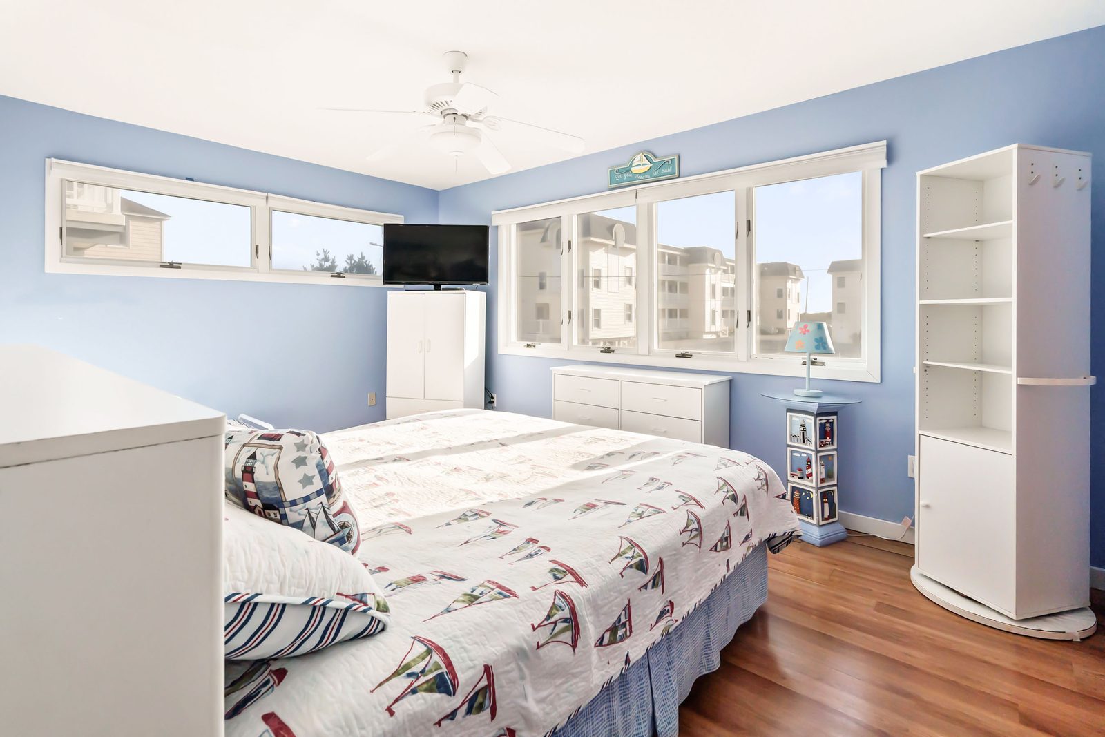 King bedroom with nautical bedding and TV